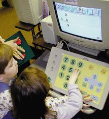 Photo of two children using an alternative keyboard to interact with computer software.